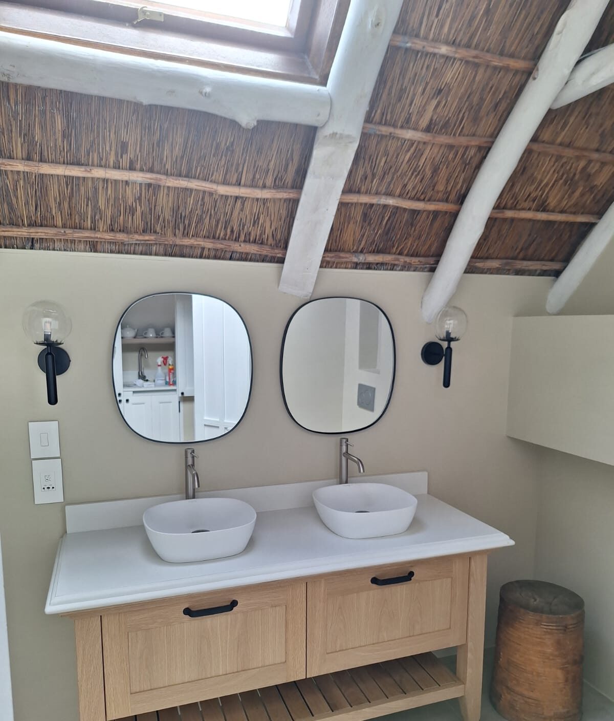 Bathroom vanity beneath a thatched ceiling