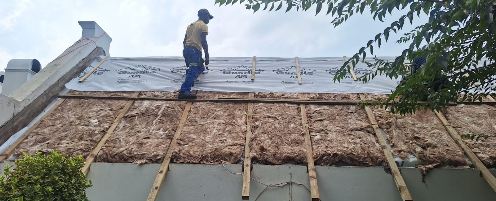 Re-thatching a roof with mountain backdrop