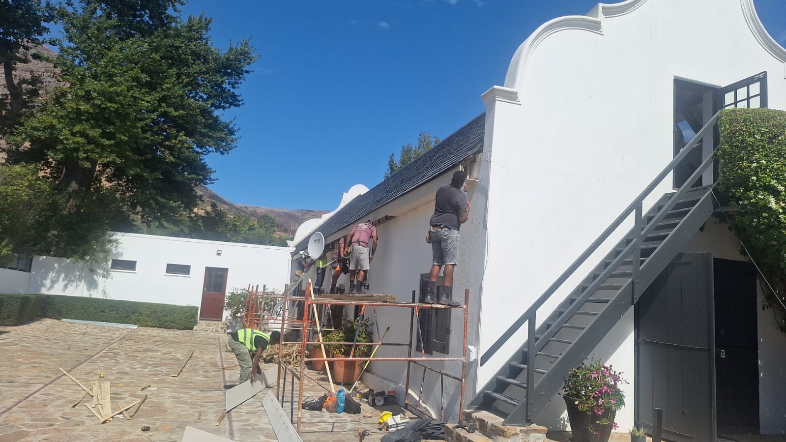 The team plastering a gable on scaffolding