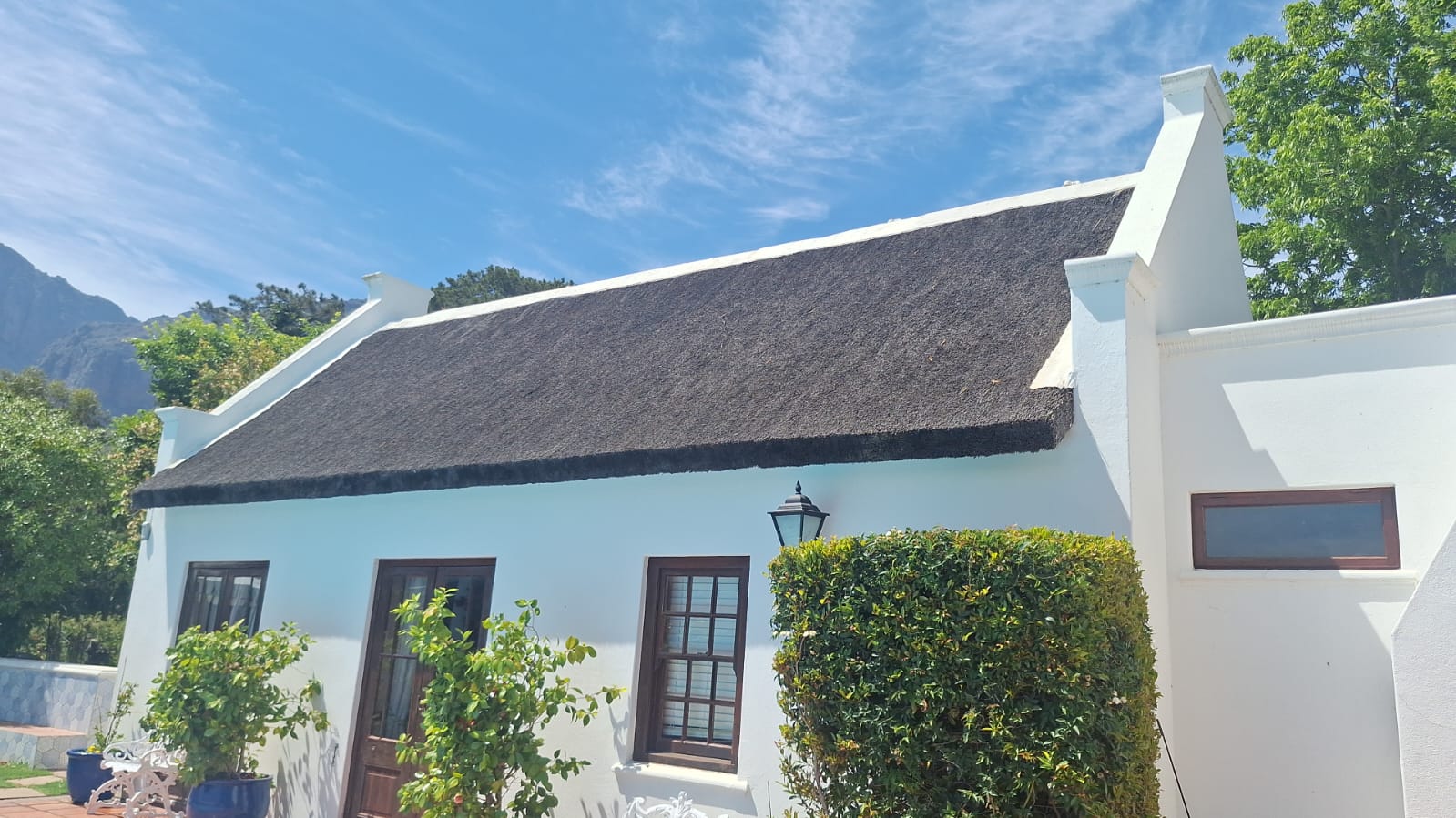Thatched cottage with mountain backdrop